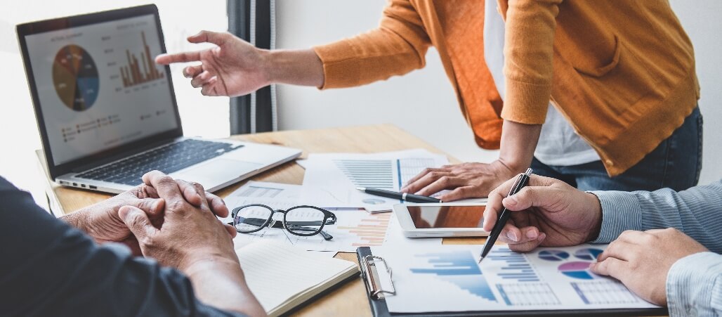 Photo of a person explaining the contents of a chart to their colleague